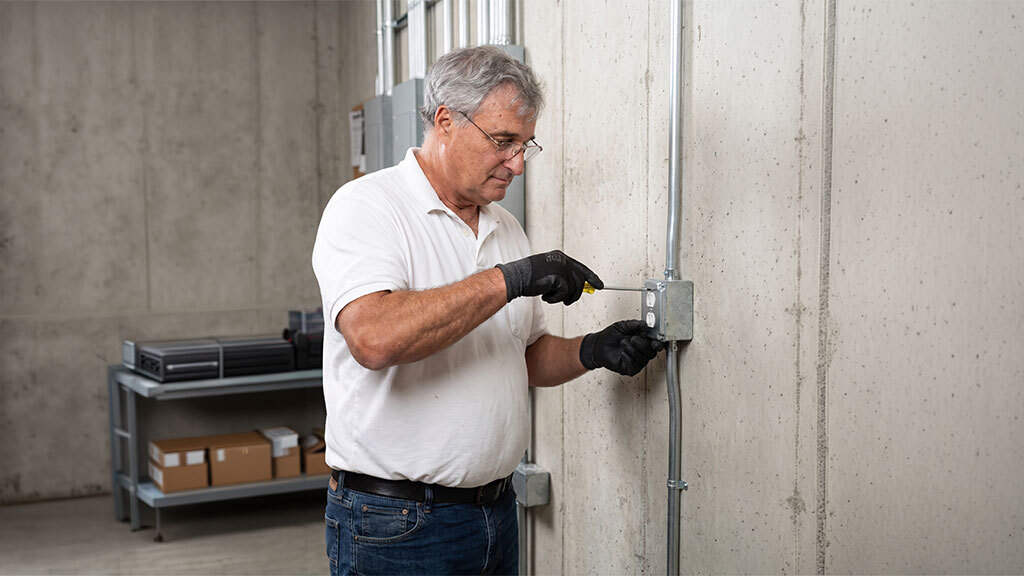 Frank Chiavarini installing an electrical outlet